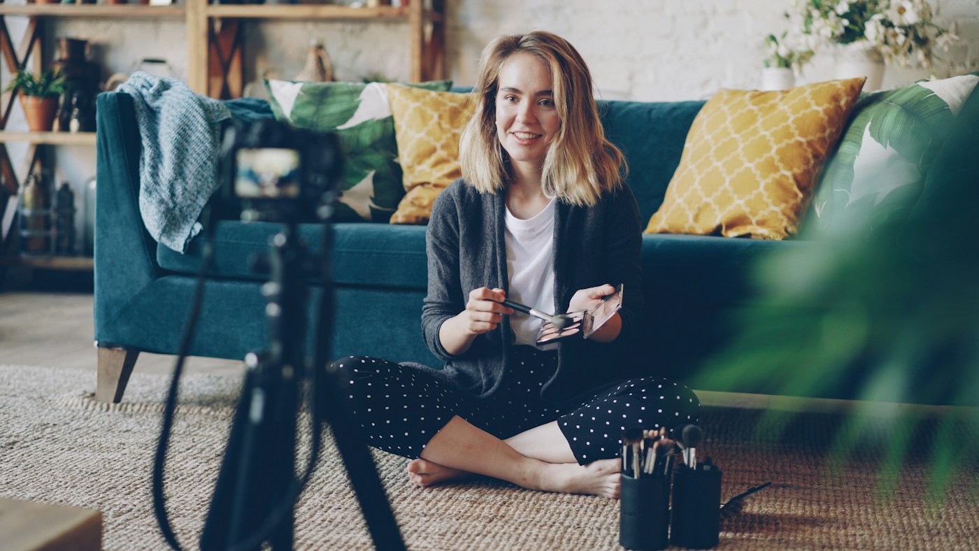 A beauty creator filming a makeup tutorial at home