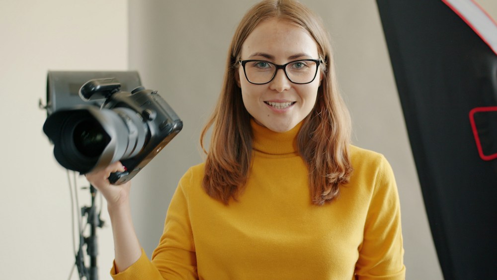 A photographer holding a camera in a creative studio